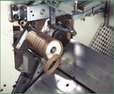 Machine cutting a paper core into designated equal lengths